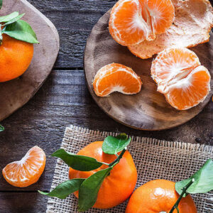 Mandarin Citrus Tree small, orange fruits - some pealed and segmented.