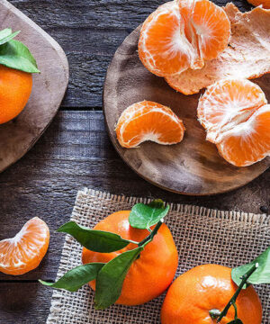 Mandarin Citrus Tree small, orange fruits - some pealed and segmented.