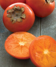 Common persimmon ornage fruit cut in half to reveal dense