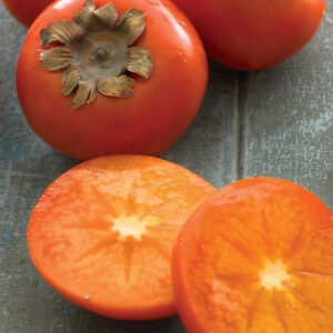 Common persimmon ornage fruit cut in half to reveal dense